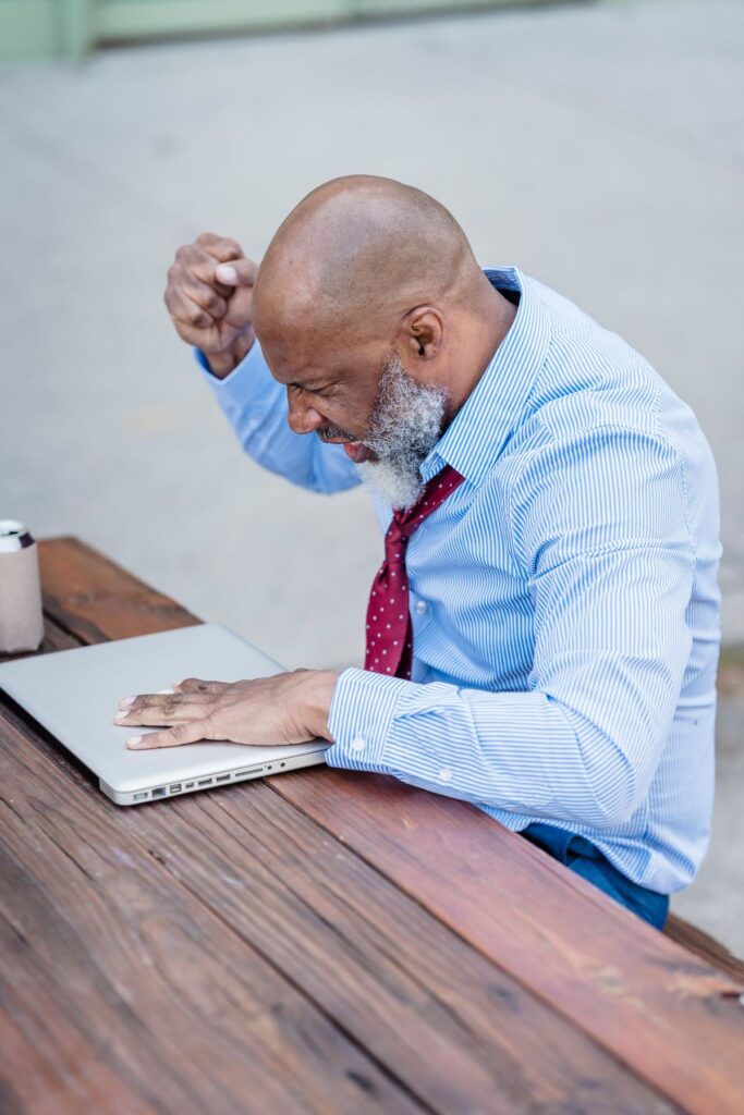 Black man working on a laptop at a table