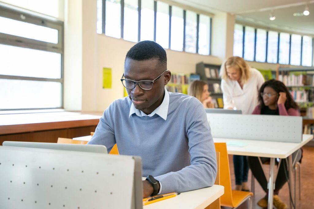Young black student browsing a laptop during a university lesson