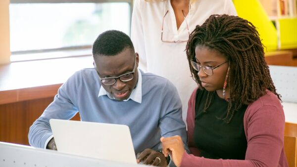 Young black students using a laptop together while preparing for exams