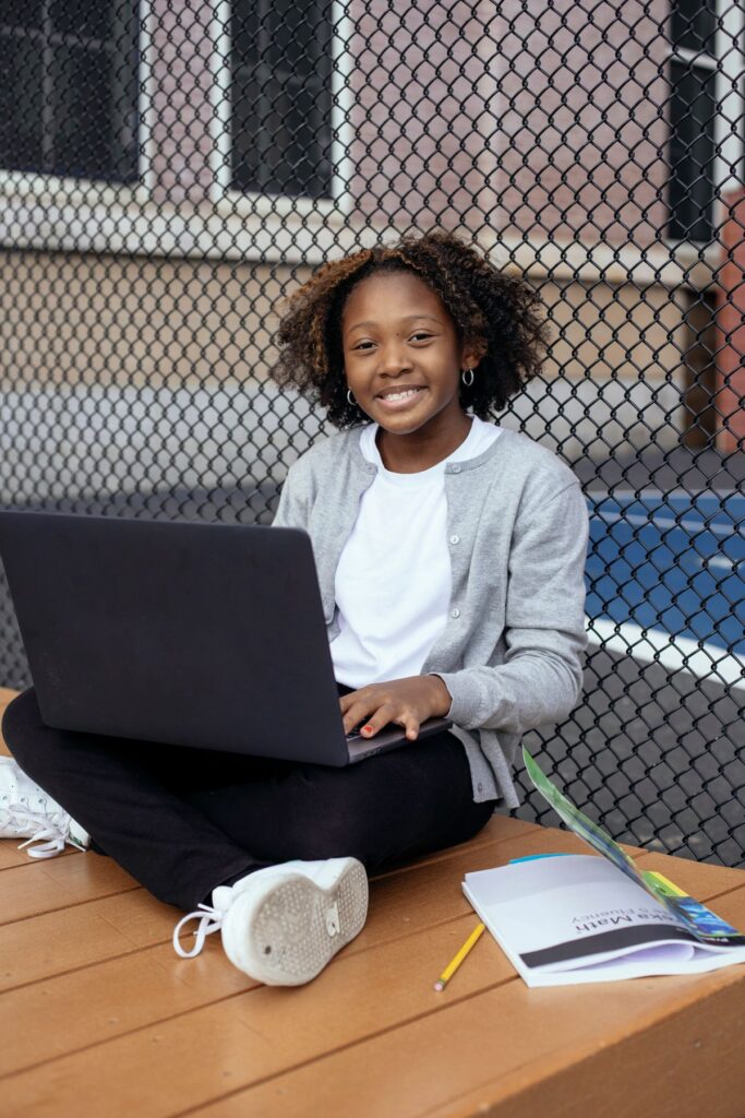 Black student studying with a laptop and textbook